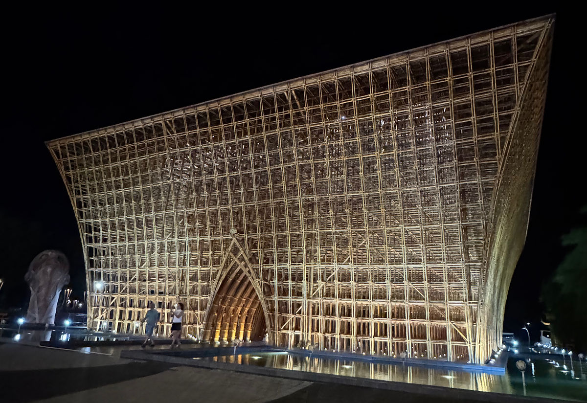 A stunning nighttime view of the Grand World Welcome Center, showcasing its intricate lattice architecture beautifully illuminated against the dark sky.